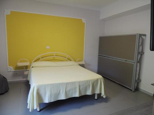 庞贝Camping Zeus的一间卧室设有一张床和黄色的墙壁