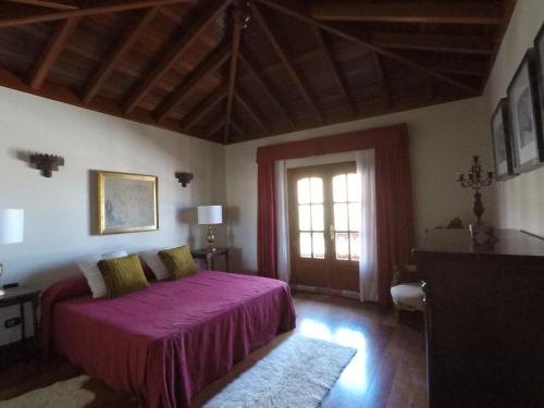 瓜蒂萨Villa la petite的一间卧室设有紫色的床和窗户