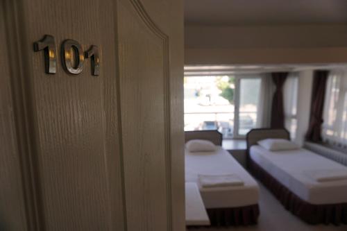 埃杰阿巴德波斯酒店的一间设有两张床的房间,墙上有数个