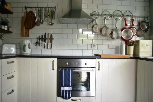海滨韦尔斯港Mousetrap的厨房配有白色橱柜和炉灶烤箱。