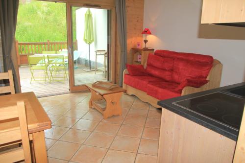 雷加霍斯达哈施At Home的客厅配有红色的沙发和桌子