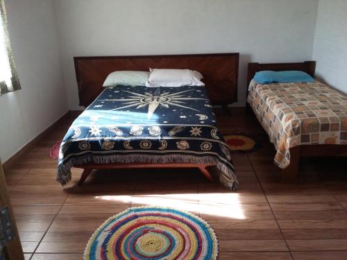 卡孔德Sítiio São Miguel projeto agroecológico的卧室配有两张床,地板上铺有地毯。