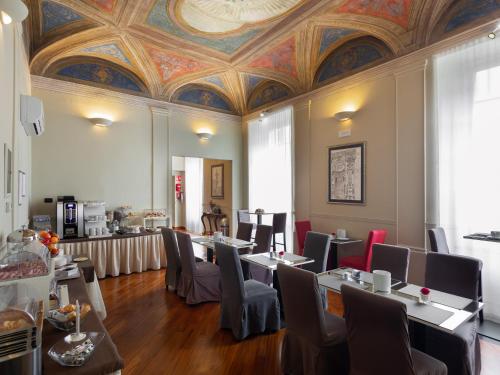热那亚新诺德酒店的一间带桌椅和天花板的用餐室