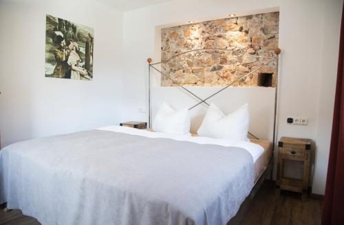 福森Altstadt Ferienwohnung An Der Stadtmauer的卧室配有白色的床和石墙
