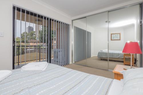悉尼Parkside Apartments Parramatta的一间卧室设有一张床和一个大窗户