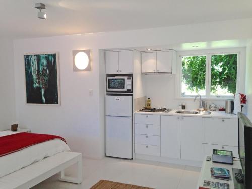 奥波蒂基Ohiwa Seascape Studios的白色的厨房配有白色橱柜和水槽