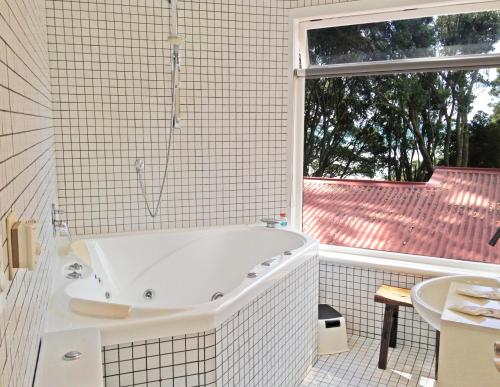 奥波蒂基Ohiwa Seascape Studios的带窗户的浴室内的白色浴缸