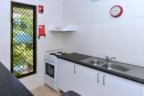 达尔文城市花园公寓 的厨房配有水槽和墙上的时钟