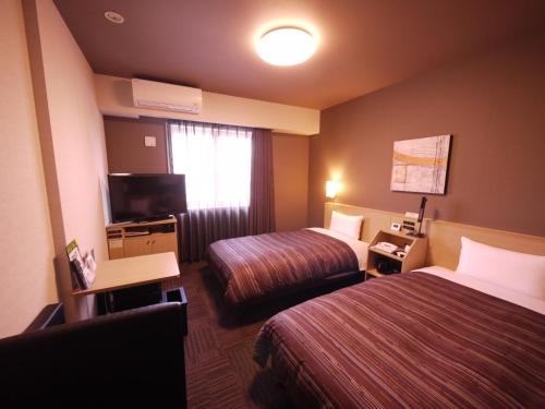 小松市格兰蒂亚小松机场路线客栈的酒店客房设有两张床和电视。