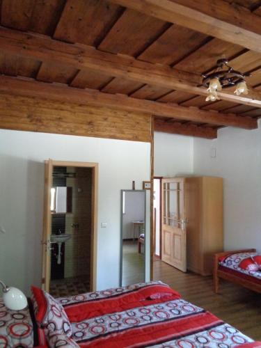 沙托劳尔尧乌伊海伊Gyöngyszemvendégház的一间卧室设有两张床和木梁天花板。