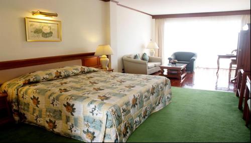 班昌普里马斯海滩水疗酒店的一间卧室,卧室内配有一张床和一把椅子