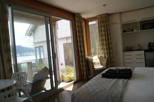 惠灵顿Oriental Bay At Its Best的一间卧室设有一张床和一个滑动玻璃门