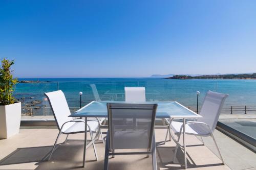 加藤-达拉特索Sonja Beachfront Apartments的一张桌子和椅子,享有海景