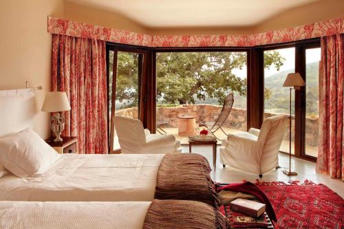 坎德莱达纳比亚酒店的一间卧室配有床和椅子以及大窗户