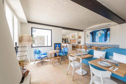 卡达克斯Boutique Hotel Villa Gala的一间带蓝色椅子的客厅和一间餐厅