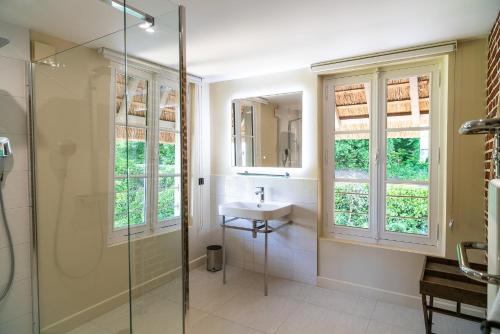 翁弗勒尔New Cottage & spa de nage Guesthouse的一间带水槽和玻璃淋浴的浴室