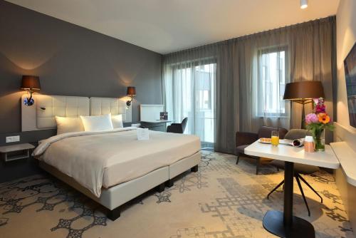 新鲁汶Martin's All Suites的酒店客房设有一张大床和一张书桌。