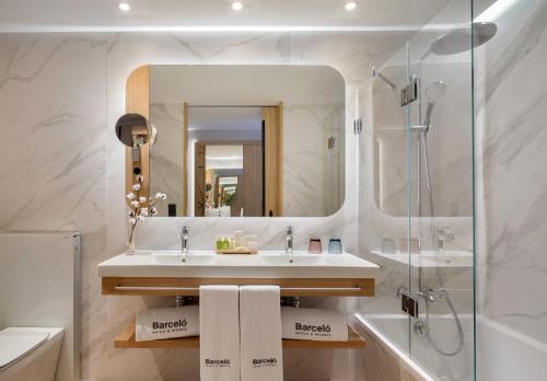 卡塞雷斯巴瑟罗卡塞雷斯五世世纪酒店的一间带水槽、淋浴和镜子的浴室