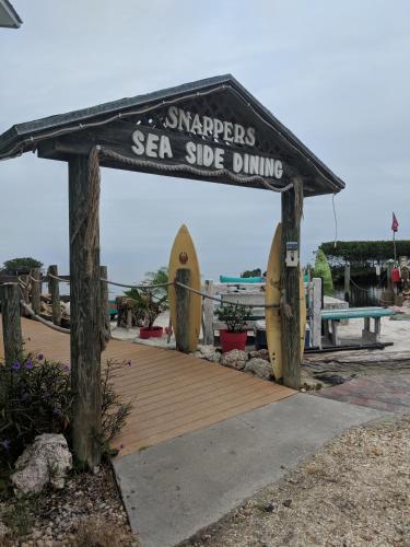 基拉戈Snappers Key Largo的木板路,上面标有重新宣传海边用餐的标志