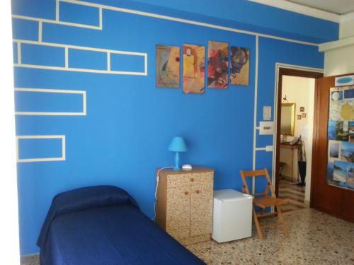特拉帕尼因特拉巴托洛住宿加早餐旅馆的蓝色卧室,配有床和椅子