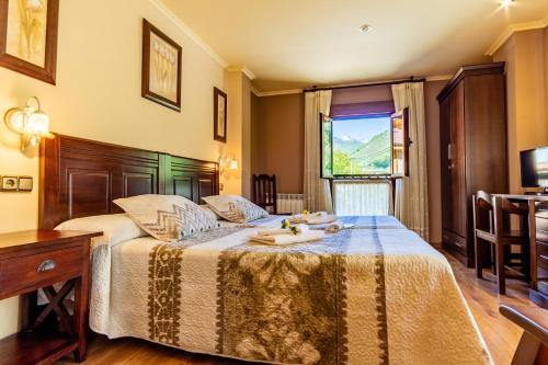 费莱乔萨Hotel Peña Pandos的一间卧室配有一张带桌子和窗户的床