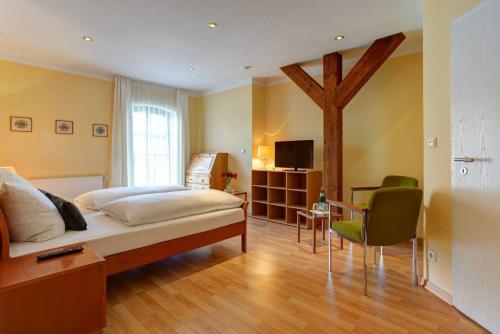 汉诺威Gasthaus Hannover的一间卧室配有一张床、一张桌子和一台电视