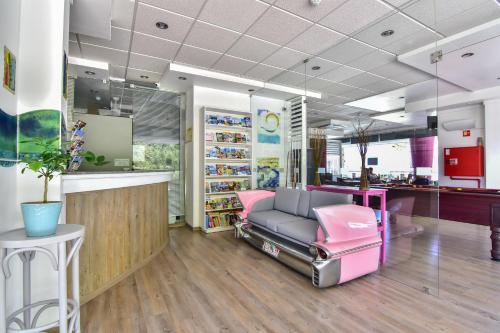 阿尔布费拉Bayside Salgados的一间位于商店的带粉红色椅子的等候室