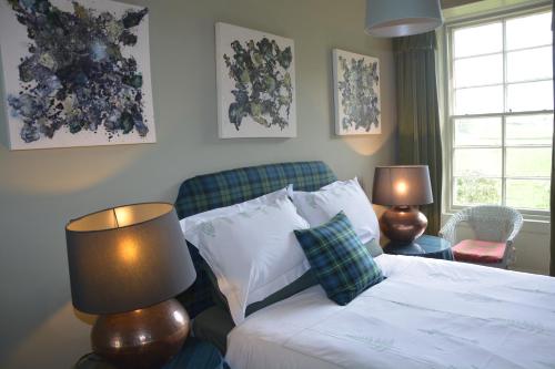 桑希尔Scaurbridge House的一间卧室配有一张带两盏灯的床和一张沙发。