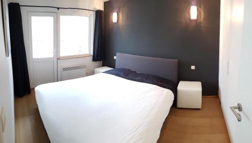 科克赛德Zeedijk 241的卧室配有白色的床和窗户。