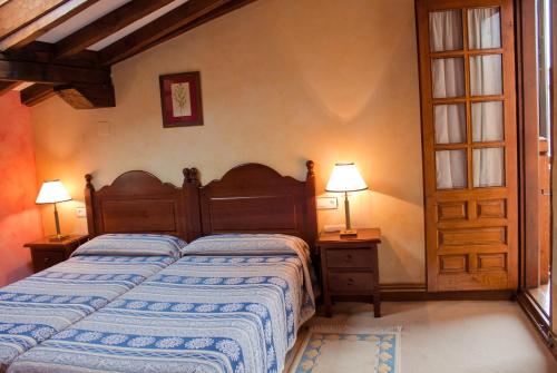 桑提亚纳德玛拉卡萨迪尔奥尔甘尼斯特乡村别墅的一间卧室配有一张床、两盏灯和一扇门
