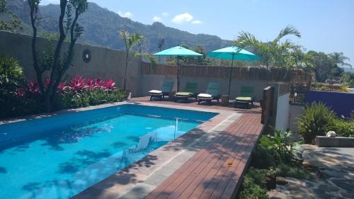 迪坡斯特兰Sierra Central By Chic Hotel Group的庭院内一个带椅子和遮阳伞的游泳池