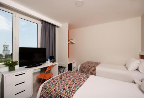 圣多明各霍德尔帕诺夫广场酒店的酒店客房设有两张床和一张书桌及电视