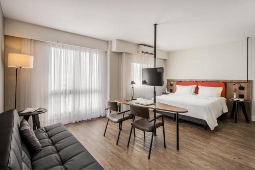阿雷格里港Intercity Porto Alegre Praia de Belas的配有一张床和一张书桌的酒店客房
