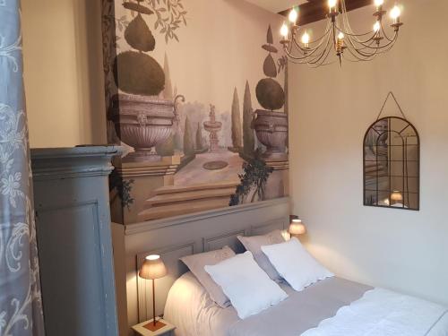 图尔Hotel Particulier Robin Quantin的一间卧室配有一张床和一个吊灯