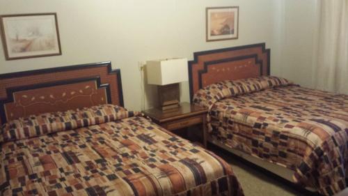 InteriorBadlands Hotel & Campground的酒店客房设有两张床和床头柜。