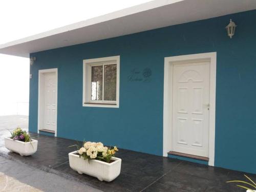 蒂哈拉费Casa Hortensia1的两扇白色门的蓝色墙,一些花