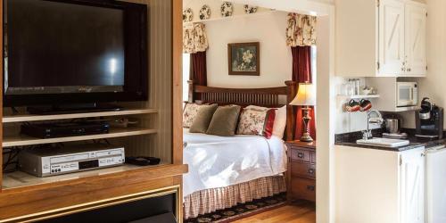 StonewallRose Hill Retreat AAA Four Diamond Inn的一间卧室配有一张床和一台平面电视