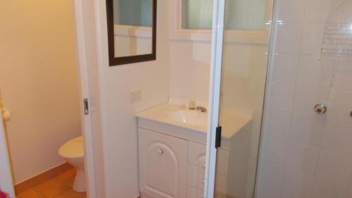 ArakoonLittle Bay Cottage - 8 East Street Arakoon的浴室配有卫生间、盥洗盆和淋浴。