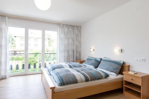 沃尔特湖畔佩莎赫Apartements Kaschitz的一间卧室配有一张带蓝色枕头的床和一扇窗户。