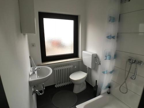 不莱梅Living @ Klassvilla Weserwehr No. 3的一间带卫生间、水槽和窗户的浴室