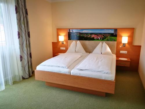 Schwanberg施万酒店及餐厅的卧室配有一张带白色床单和枕头的大床。