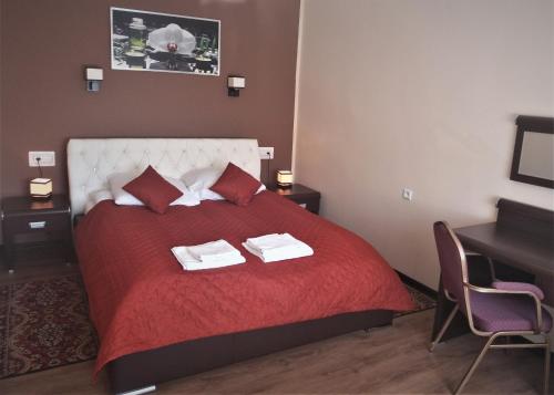 塞伊内Hotel Skarpa的一间卧室配有红色的床和2条毛巾