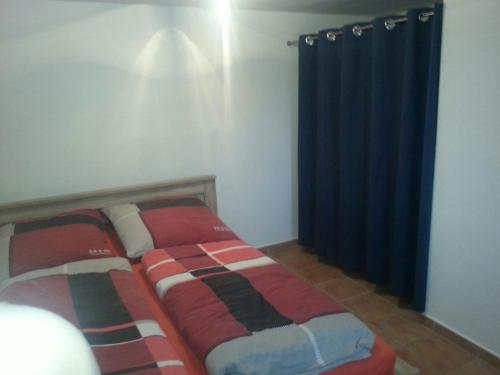 RotterodeFerienhaus Moosbachtal Thüringer Wald bei Oberhof的一间卧室配有床和蓝色窗帘
