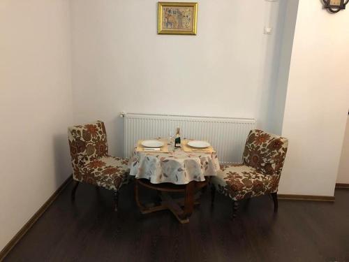 锡比乌Homestay Marius的一张桌子,两把椅子,一张桌子,上面有盘子