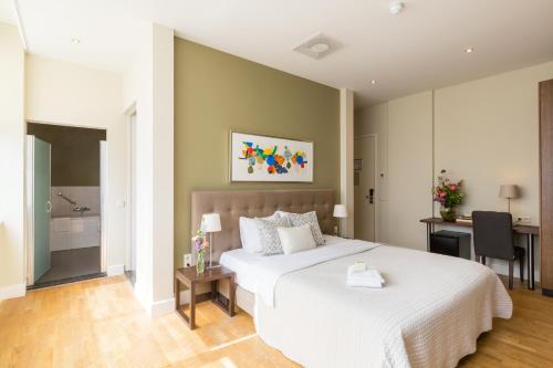 埃因霍温卢米埃尔精品酒店的一间带白色床的卧室和一间浴室