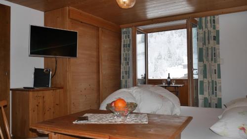 图克斯Pension Bergkristall的客房设有一张带桌子的床和一台电视