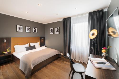 杜塞尔多夫杜塞尔多夫米特酒店 的酒店客房配有一张床、一张书桌和一张书桌。