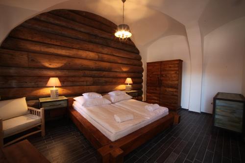 德布勒森Régi Posta Étterem és Fogadó的一间卧室设有一张带木墙的大床