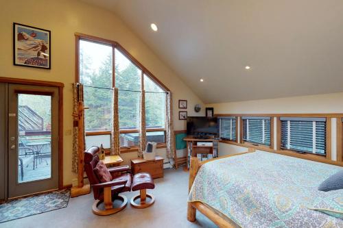 哥德伍德Crow Creek的一间卧室配有一张床、一张书桌和一些窗户。