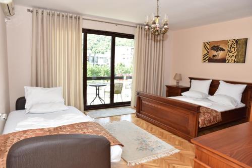 乌尔齐尼Guest House Evropa的一间卧室设有两张床、一张桌子和一个窗口。
